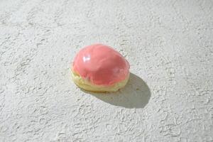 a pastry or mini donut with a pink icing on it photo