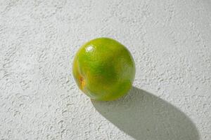 a orange lime on a white wall photo