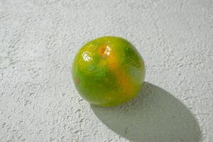 a lime orange on a white surface photo