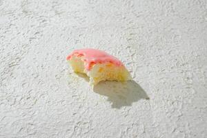 a half eaten mini donut on a white surface photo