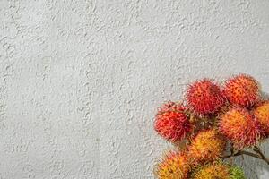 red rambutan fruit with its distinctive hairy shell, isolated on a textured white background, emphasizing its unique appearance photo