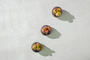 Mangosteen fruit displayed against a textured white background, emphasizing its unique purple rind and freshness. perfect for digital asset and deisng fruit photo