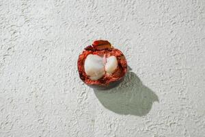 a mangosteen fruit with a shell on it. isolated on white texture background photo
