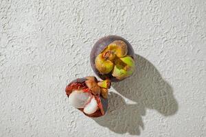 a mangosteen fruit with a seed inside of it. isolated on white texture background photo