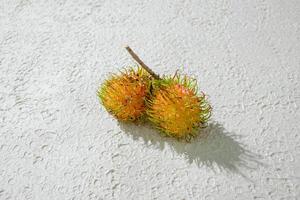 Fresh yellow rambutan on a textured white background, perfect as a digital asset for design projects, posters, advertisements, or creative media photo
