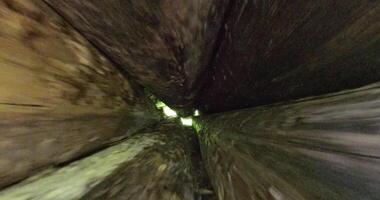 Camera moves from inside a stack of logs to reveal the full pile from the outside video