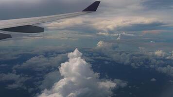 View of the wing of an airplane in flight. Flying high above the clouds. Porthole video
