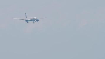 Airliner approaching landing, side view. Jet plane with unrecognizable livery descending, arriving, long shot. Aircraft in the blue sky video