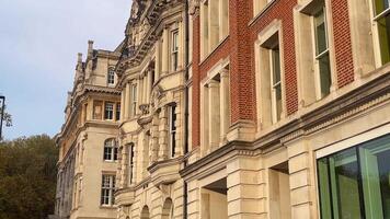 A stunning blend of red brick and beige stone architecture, showcasing elegant windows and ornate detailing in a historic British building video