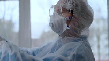 Doctor in protective suit examine x-ray for pneumonia of a Covid-19 patient in the clinic. Coronavirus pandemic concept video