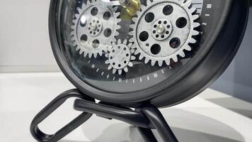 This vintage mechanical clock features intricate exposed silver gears on a sleek black stand, adding style and sophistication to any decor and enhancing your spaces aesthetic appeal video