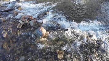 A breathtaking and picturesque view of a stream gracefully flowing over a rocky bed, showcasing crystal clear waters and gentle waves, creating a serene and tranquil natural environment video