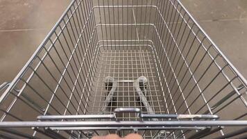 An empty shopping cart reveals its sturdy frame and expansive open space, offering a unique perspective as eager shoppers prepare for their adventurous grocery shopping journey ahead video