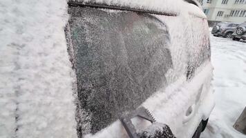 A person cleaning snow and ice from their car window highlights harsh winter weather and stresses the importance of regular vehicle maintenance for safety in extreme cold video
