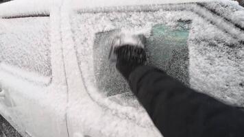 A snowcovered vehicle with a clear patch on its windshield highlights winters harshness. A person shovels snow, showcasing the proactive steps homeowners take for winter preparedness video