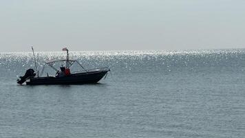 Solitude on the Horizon A lone boat, silhouetted against a shimmering expanse of water, evokes a sense of tranquility and endless possibilities. video