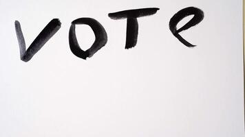 Hand writing vote and then changing to no on white paper with brush stroke technique in uhd. video