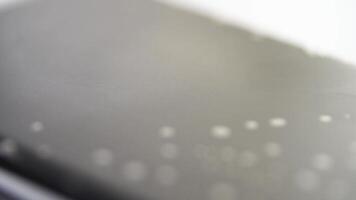 Closeup of water droplets on a smooth surface showing changes in focus and light reflections over time. video