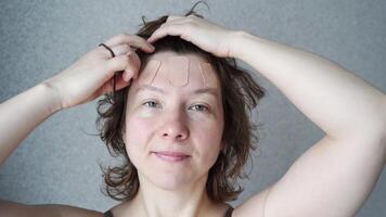 Caucasian young woman expressing joyful emotions through facial massage routine in highresolution sequence. video