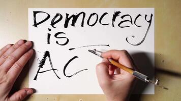 escritura lapso de tiempo transformando democracia es C.A a democracia es acción con cepillo bolígrafo en papel. video