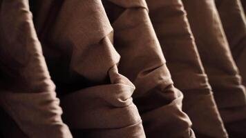 Closeup of elegantly draped brown fabrics in gentle motion highlighting texture and folds. video