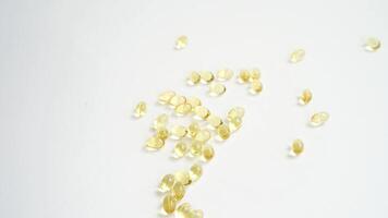 Capsules spilling and scattering across a white surface creating dynamic flow and movement. video