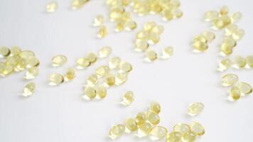 Closeup sequence of hands sorting and arranging omega3 capsules across a white surface in various angles. video