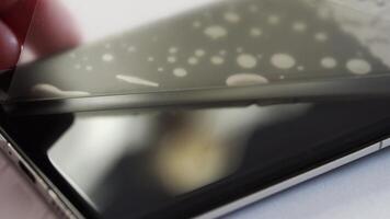 Applying screen protector on smartphone closeup sequence of precise alignment and bubblefree surface. video