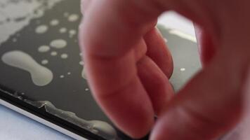 BARNAUL, SIBERIA, ALTAI REGION, RUSSIA - 15 June 2024. Applying and removing protective film from smartphone screen with precision and care. video