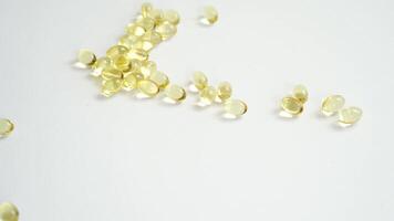 Golden capsules pouring in sequence on white surface health supplement flow sensation. video