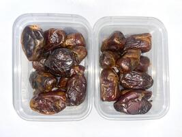 two plastic containers filled with dates photo