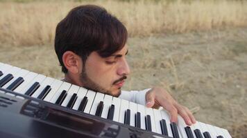 Young Man Walks Playing Musical Keyboard On Shoulder In Nature video