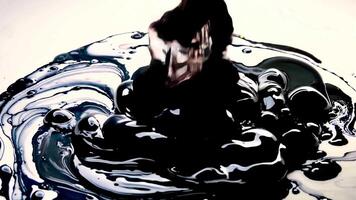 A woman sitting on top of a black and white swirl video