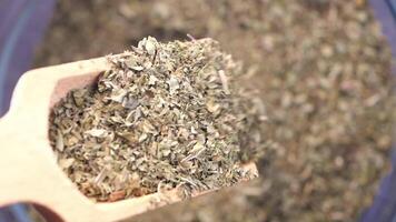 Wooden scoop with dried herbs for culinary uses and applications video