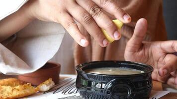 Squeezing a Fresh Lemon into a Bowl of Delicious Soup for Enhanced Flavor and Freshness video