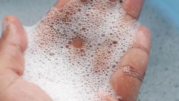 A detailed closeup view of soapy foam resting gently in a hand video