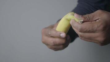 A closeup of a person peeling a banana, showcasing its color and texture video