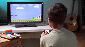 Child playing retro games at home using a joystick and tv screen video