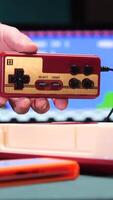 vertical Man holding retro game controller playing on a vintage console video