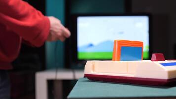 Gamer playing with a retro game console and holding a joystick video