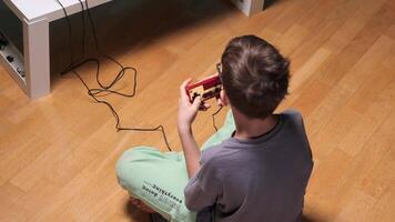 Boy playing retro game console sitting on the floor video