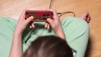 Child playing retro games with red and gold controller video