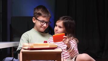 Two happy children playing with a retro game console at home video
