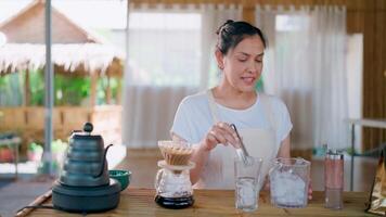 sorridente barista fermentação café. uma mulher dentro a avental sorrisos Como ela prepara uma refrescante café beber dentro uma rústico cafeteria contexto, criando uma caloroso e convidativo atmosfera. video