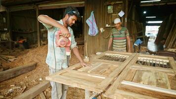 Two carpenters in work shop working with blower video