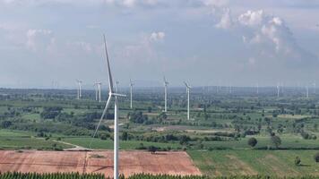 Panoramic view of a large wind farm with multiple wind turbines scattered across a lush agricultural landscape, highlighting renewable energy production, sustainability, video
