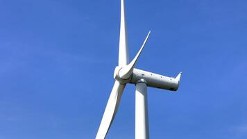 a large wind turbine with a blue sky in the background. video