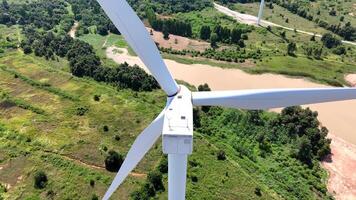 Wind turbine hub and blades overlooking a vast green countryside, showcasing sustainable energy solutions, environmental conservation, and advancements in renewable power technology video