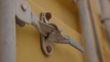 An Intricate Close Up View of a Metal Latch Affixed to a Bright Yellow Container. Stock Footage video