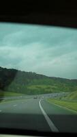 look in the rear view mirror of a car. View from the window of the mountains in the car's rearview mirror. Travel by personal car, concept. video